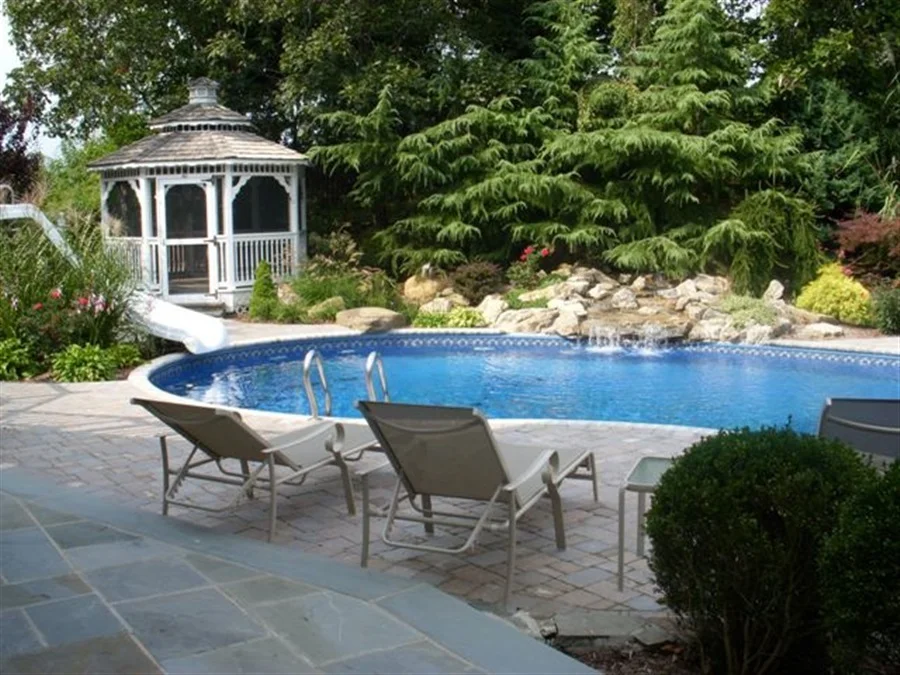 landscaped garden with trees, plants and gazebo - all surrounding an inground pool