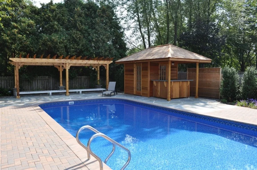 inground pool with pavers and small cabana