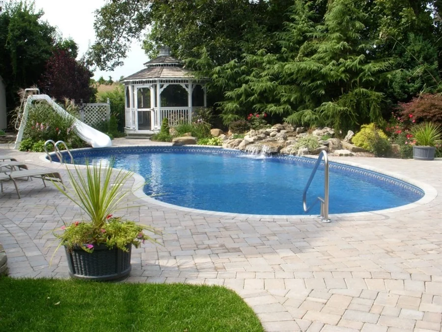 landscaped garden with trees and plants surrounding an inground pool
